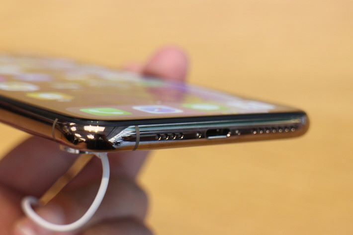 機底喇叭左右開孔數同 iPhone X 不同，也有多一條天線位在機身底。